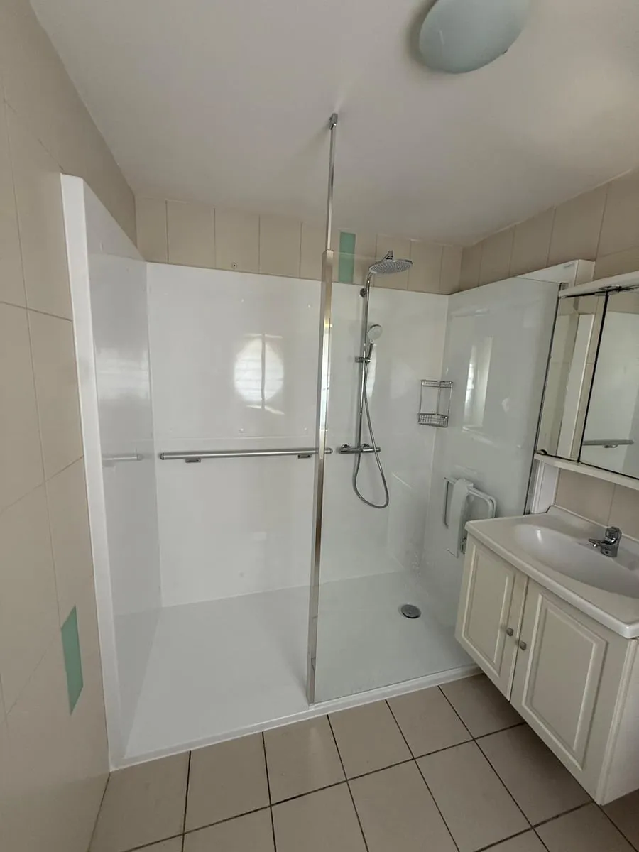 La même salle de bains avec une douche de plain-pied, après les travaux (1/10)